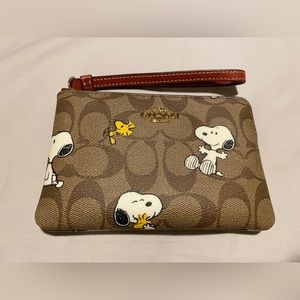 Coach x Peanuts Corner Zip Wristlet In Signature Canvas With Snoopy & Woodstock